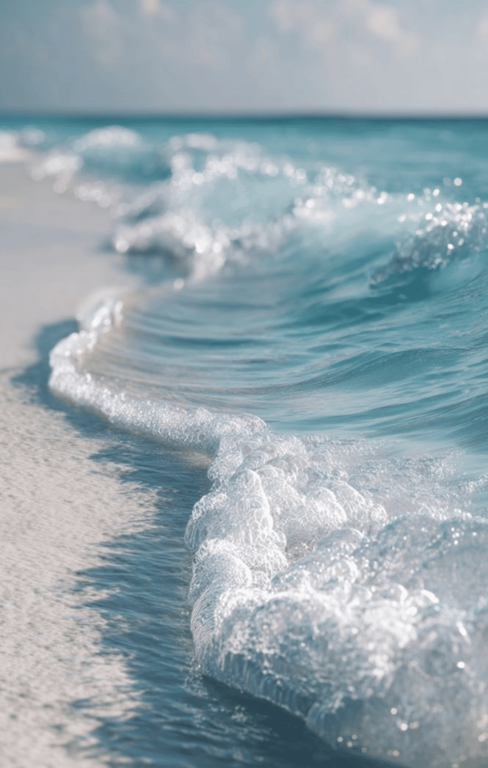 Ocean wave rolling onto white sand