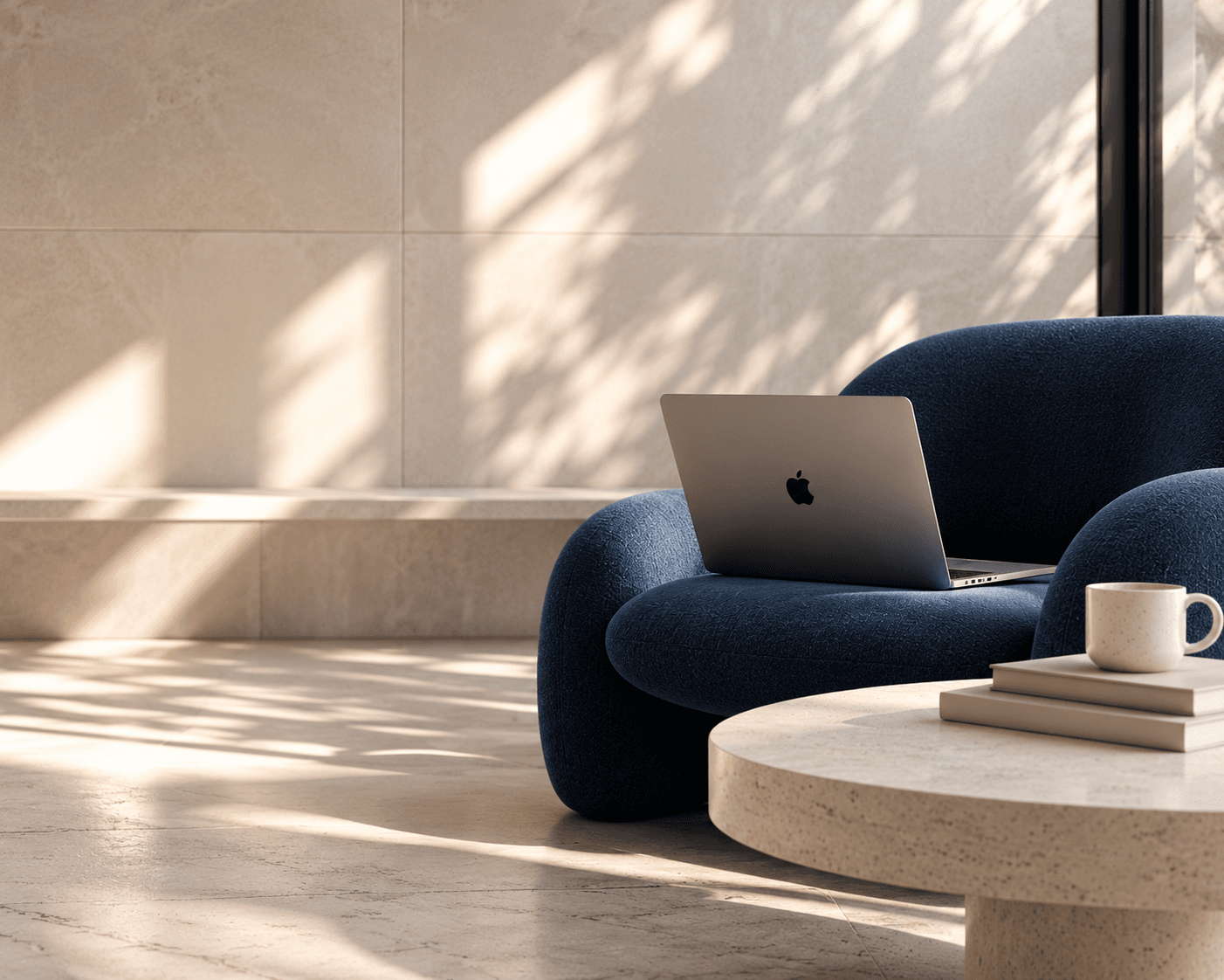 Sunlit room with a laptop on a navy sofa